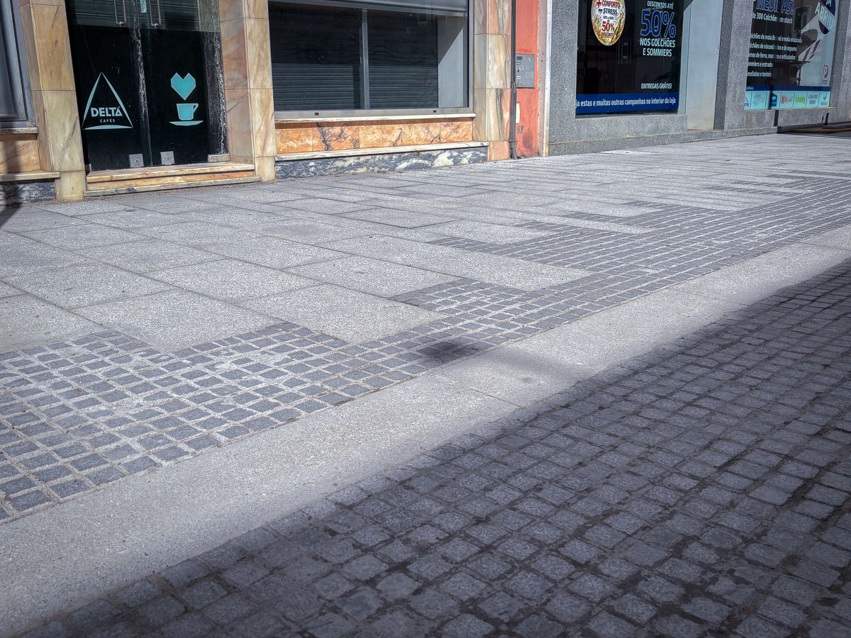 Pavimento em cubo de granito numa rua comercial