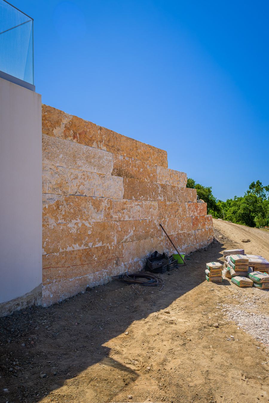 Muro de suporte em pedra natural junto a uma moradia